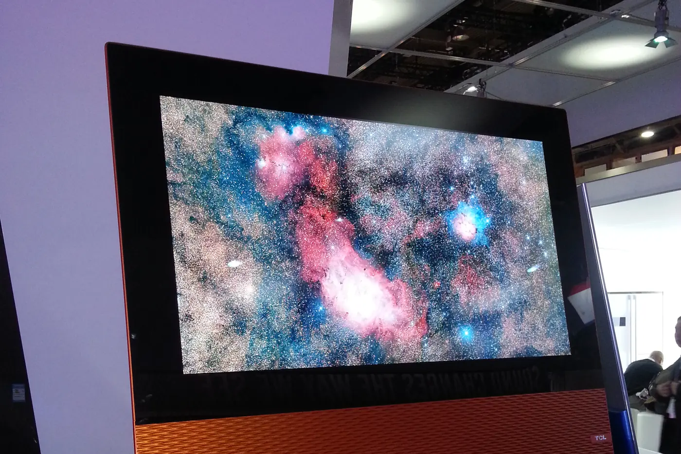The Canvas OLED TV on the TCL stand at CES 2014, seen from the front: a nebula on screen above its orange textured base.