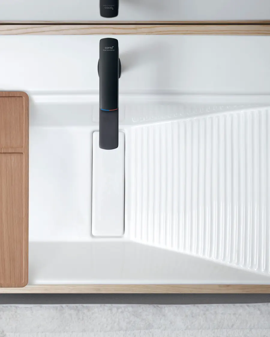 A matte black Cotto Skive faucet over a white ribbed basin.