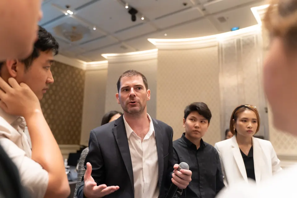 Sébastien, microphone in hand, coaching a circle of business owners.