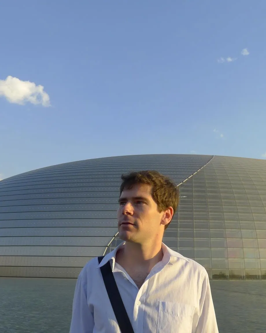 Sébastien in a white shirt in front of the National Centre for the Performing Arts in Beijing, 2011.